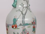 a white vase with a painting on it sitting on a table