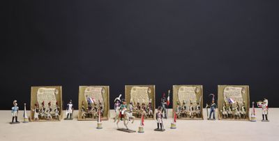 de nombreuses figurines représentant des personnes debout devant un cadre photo