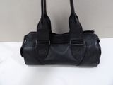 sac à main en cuir noir muni de deux anses, sur fond blanc