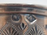 a close up of a silver plate with an owl on it