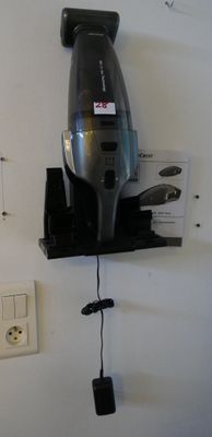 un sèche-cheveux accroché au mur à côté d'une prise électrique