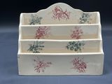 a picture of a three tiered display case with flowers on it