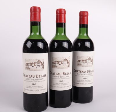 trois bouteilles de vin rouge sont alignées sur une surface blanche