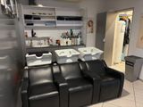 a photo of a hair salon with a lot of chairs