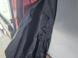 a black jacket hanging on the wall next to a refrigerator