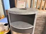 a corner cabinet with a shelf on top of it