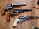 deux revolvers posés sur un parquet, à côté d'une paire de chaussures
