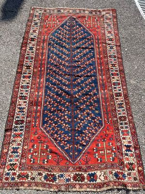 a red and blue rug sitting on top of a sidewalk