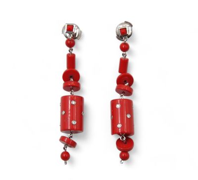 a pair of red beads and silver earrings on a white background