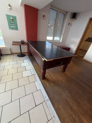 une table de billard au milieu de la pièce