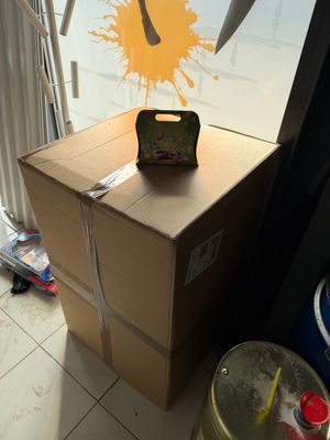 une boîte en carton sur laquelle est peinte une image, avec une paire de ciseaux posée dessus