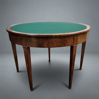 an oval table with a green glass top and wooden legs