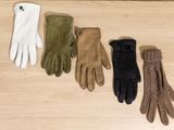 four pairs of gloves are lined up on a wooden surface