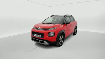Une Citroën rouge est garée dans une pièce blanche