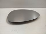 une souris argentée posée sur une surface blanche