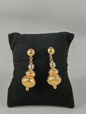 a close up of a pair of earrings on a pillow
