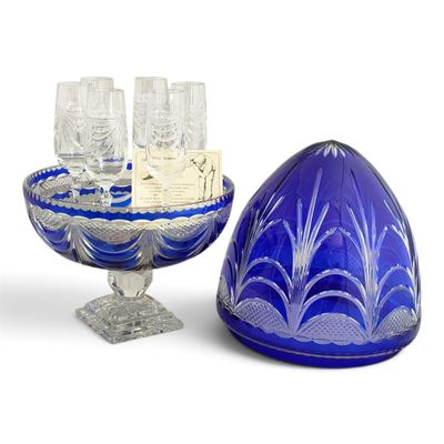 un saladier en verre bleu contenant des verres à vin et un plateau sur lequel sont posés des verres à vin