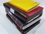 several books stacked on top of each other on a white surface