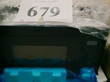 un micro-ondes dans un carton sur lequel est collée une étiquette de prix