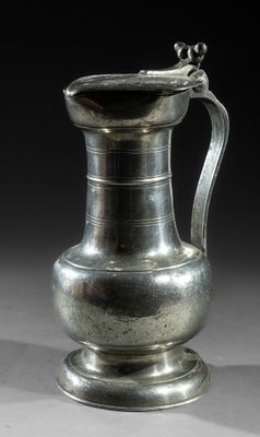 an image of a silver vase with a handle on a table
