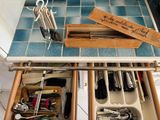 a drawer with utensils and other kitchen utensils in it