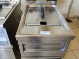 two deep fryers sitting on the floor in the kitchen