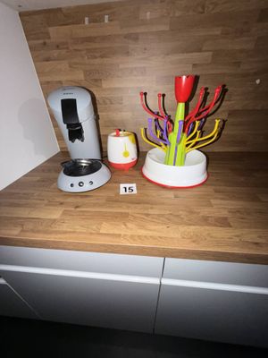 une cafetière posée sur le plan de travail, à côté d'un vase de fleurs