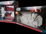 two boxes of star wars toys sit side by side on a black background