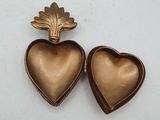 two gold heart shaped lockes sitting on top of a white surface