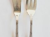 deux fourchettes et un couteau sur une table blanche