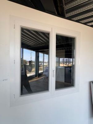 deux fenêtres sur le côté d'un bâtiment blanc