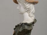 a bust of a woman wearing a hat with a bird on top of it