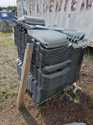 une pile de chaises en plastique empilées les unes sur les autres devant une caravane