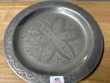 a silver plate sitting on top of a wooden table