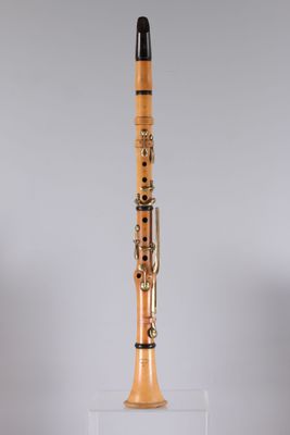 a clarinet with a wooden body and a black top on a clear stand