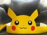 pokemon pikachu paper crown on a chair with a black background