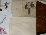 des dessins représentant des personnes sur une feuille de papier posée sur un lit