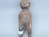 une petite figurine représentant un homme coiffé d'un chapeau