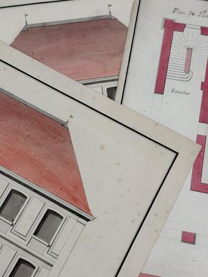 plusieurs anciens plans architecturaux d'une maison posés sur une table