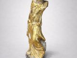 une image représentant une statue d'une femme vêtue d'une robe dorée