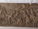 un vieux panneau en bois orné de sculptures, posé sur une table