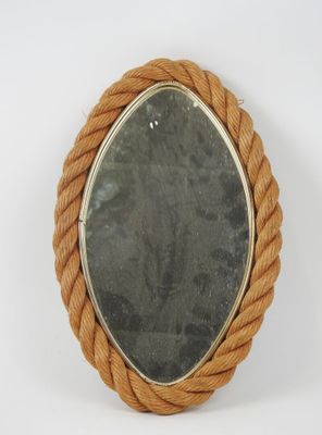 an oval mirror with rope wrapped around it on a white surface