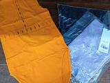 a yellow shirt and a pair of underwear on a wooden floor