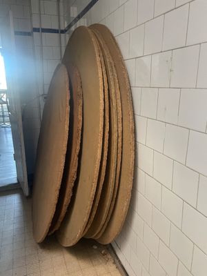 une pile d'assiettes en bois posée par terre dans une salle de bains
