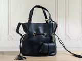a black leather handbag with tassels on a wooden floor