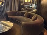 a living room with a curved couch and a round coffee table