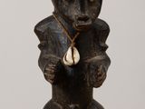 wooden figurine of a bear holding a shell on a table