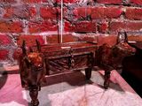 une statue représentant un taureau et une table sur laquelle se trouve une lampe