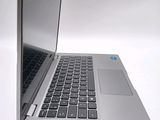 a silver laptop with a black keyboard on a white surface