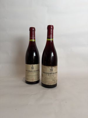 two bottles of wine sitting on a table next to each other